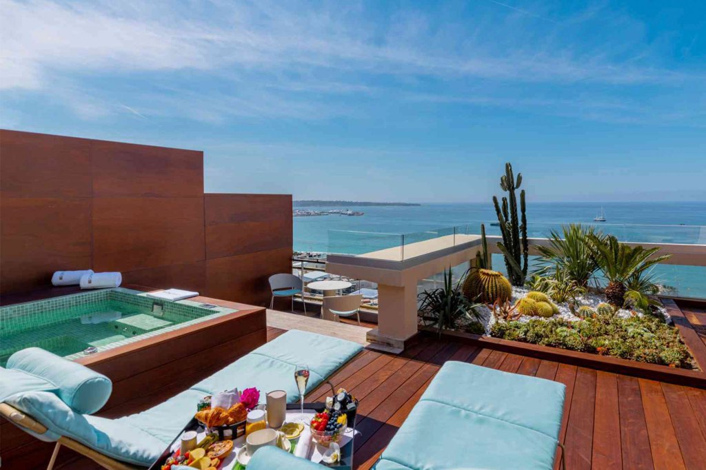 Rooftop terrace with hot tub overlooking ocean.