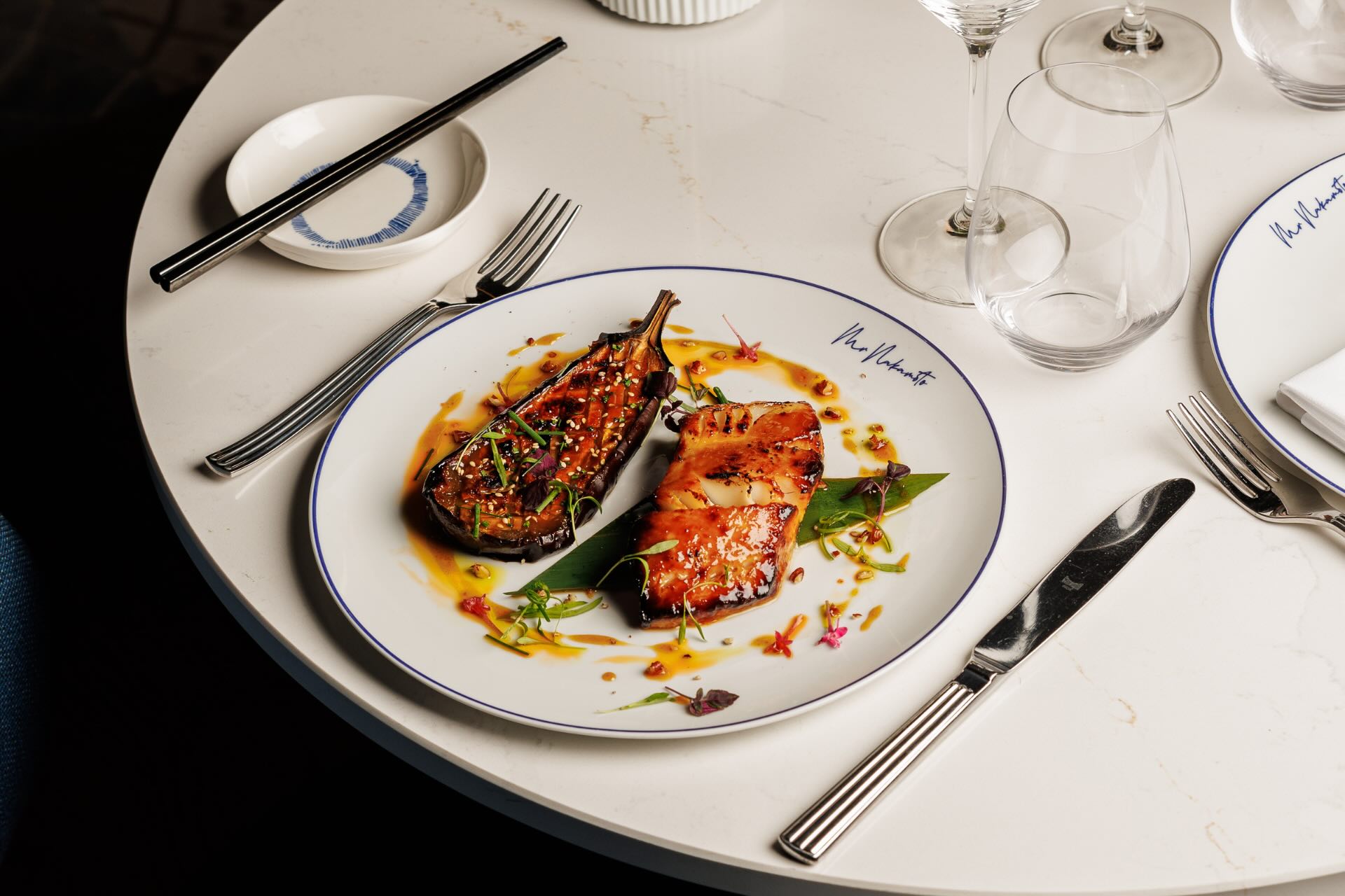 A blue chair at a table set with a plate of food at a restaurant