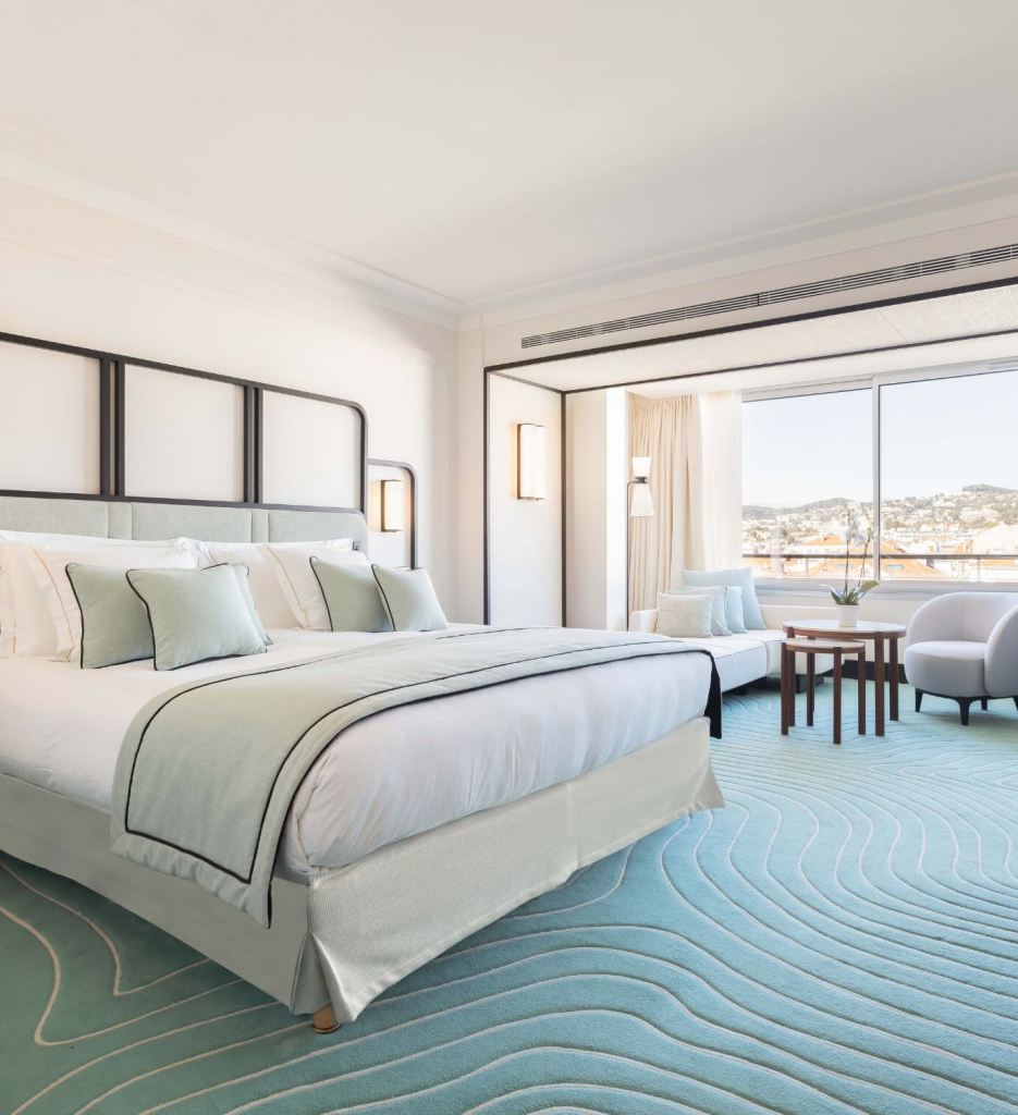 a beautiful room at Mondrian Cannes with a blue rug and city view