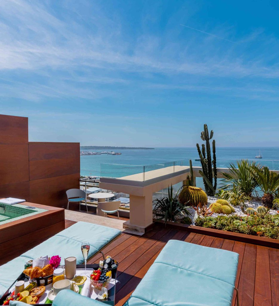 Rooftop terrace with hot tub overlooking ocean.