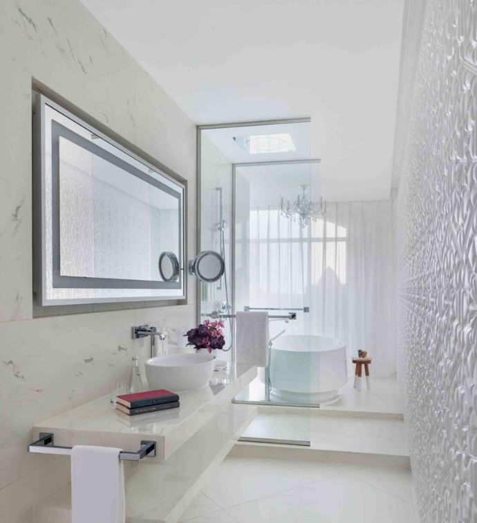 All white bathroom with a sink, mirrors, shower and tub 