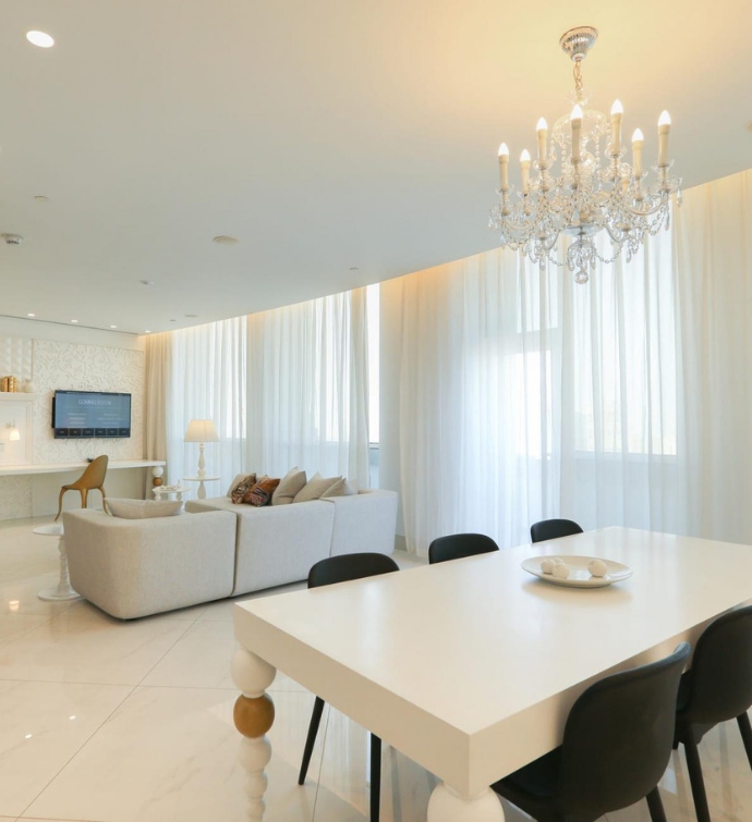 Living space with a table, couches, TV and chandelier