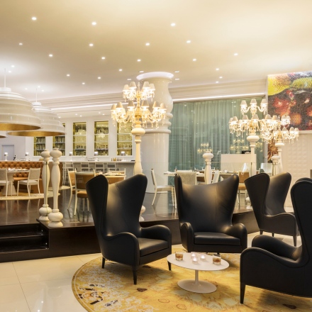 Interior of Mondrian Bistro, with tall, black chairs and chandeliers 