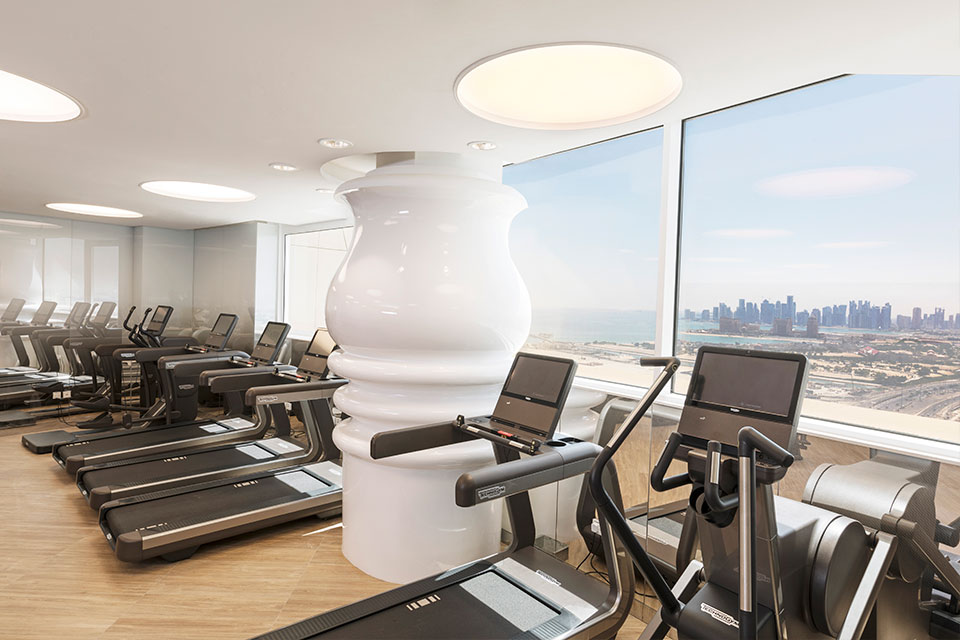 Mondrian Doha fitness space with treadmills and views of the city.