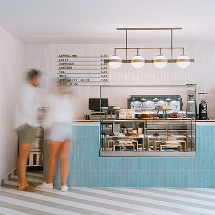 Blue coffee counter with blurred-out people standing in line.