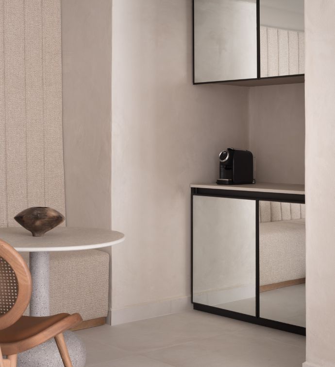 Kitchen with a small white table and brown chair with mirrored kitchen cabinets