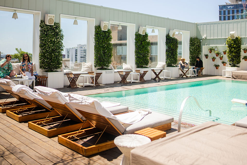 Skybar LA rooftop pool with daybeds and large windows with views of Los Angeles.