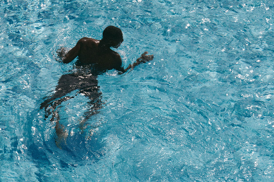 Man swimming in crystal clear pool waters at Mondrian Los Angeles.