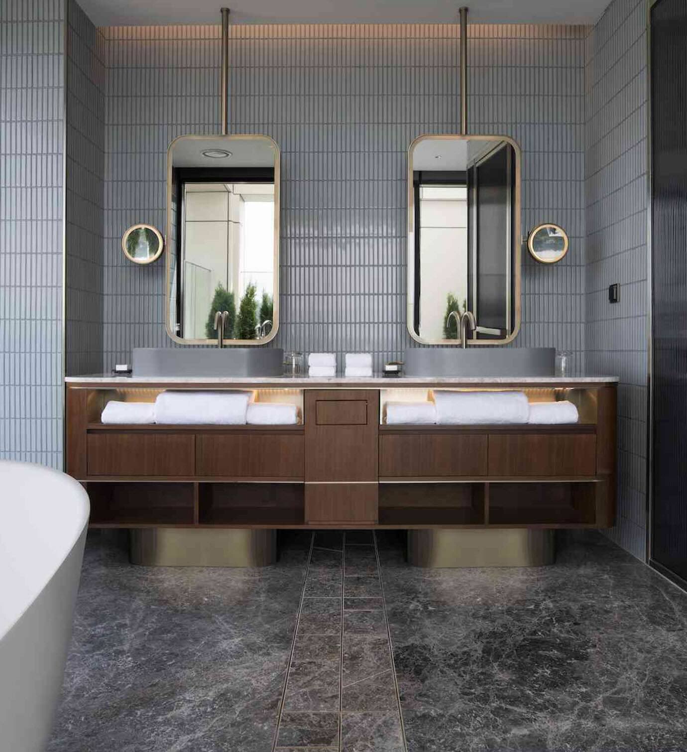 Grey bathroom with double sinks and modern gold framed mirrors