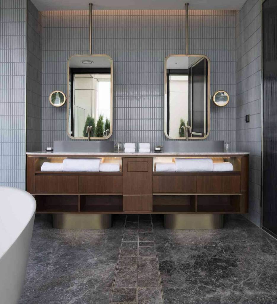 Grey bathroom with double sinks and modern gold framed mirrors