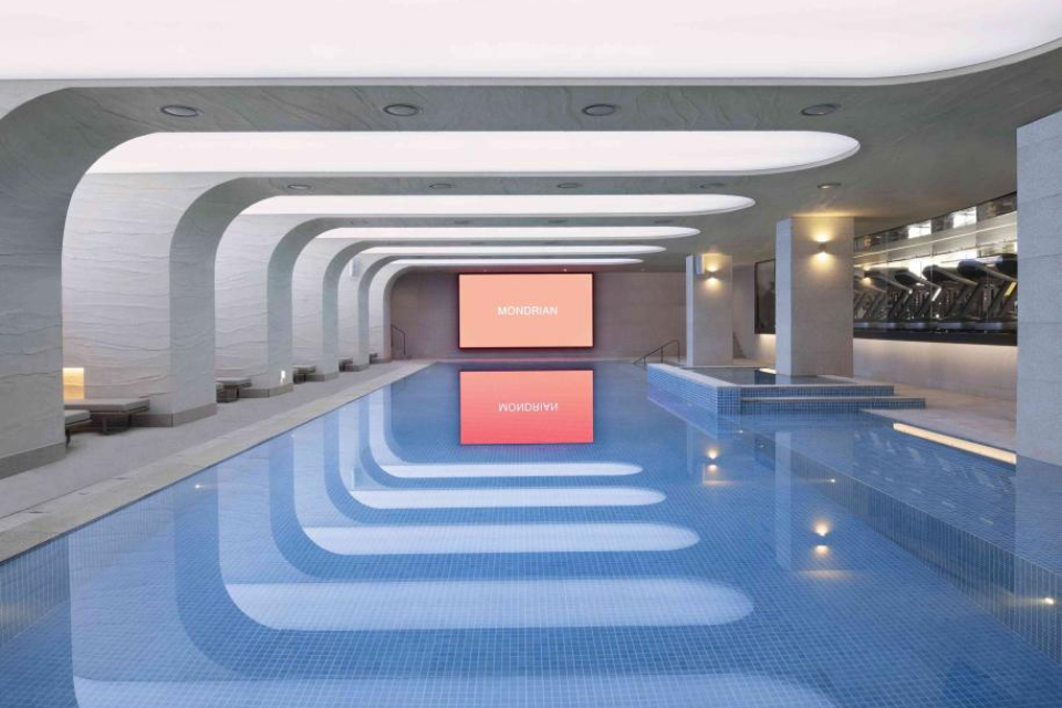 an indoor swimming pool with modern architecture and a large screen 