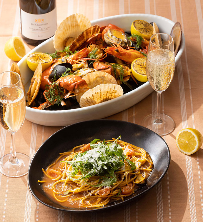 Seafood and spaghetti dishes with two glasses of champagne