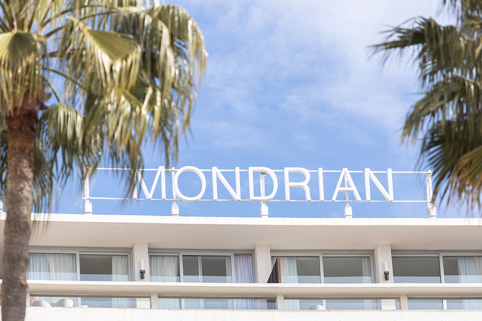 Mondrian signage on top of the Cannes property, framed by palm trees