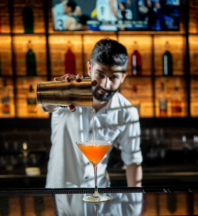 Bartender pouring a martini at Hudson Tavern Doha