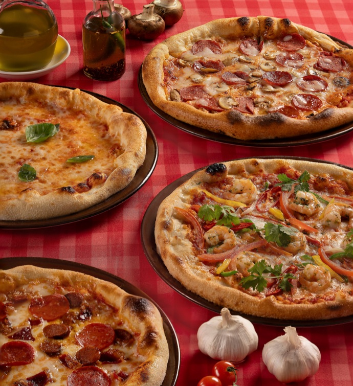 Four different types of pizzas on a table with a red checkered tablecloth