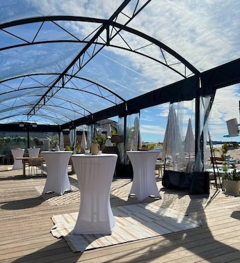 Outdoor patio with round top covered bar tables and white umbrellas