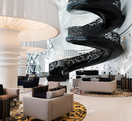 Reception at Mondrian Doha featuring an oversized staircase and lamps