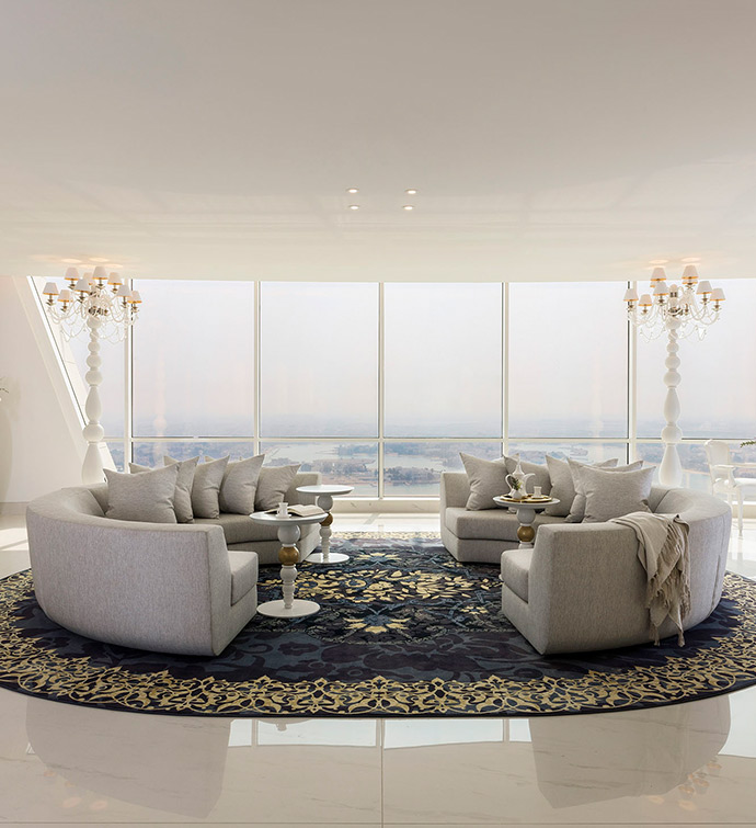 A cozy living room with a spacious rug, couch and a sizable table with city views.