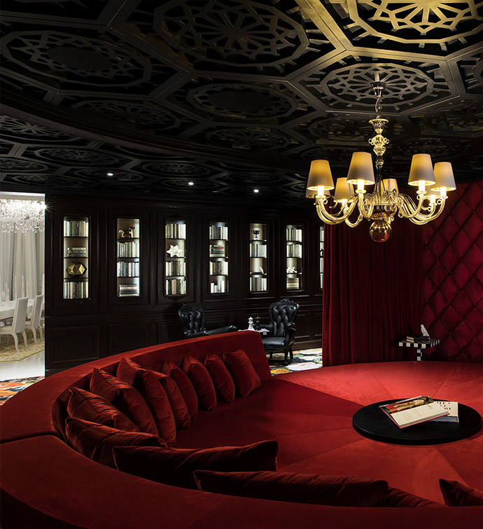 A room with a chandelier and a red couch.