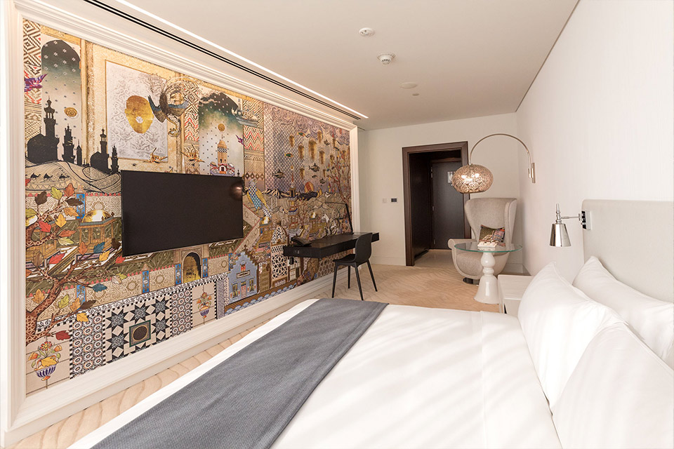 A hotel room featuring a colorful wall mural.