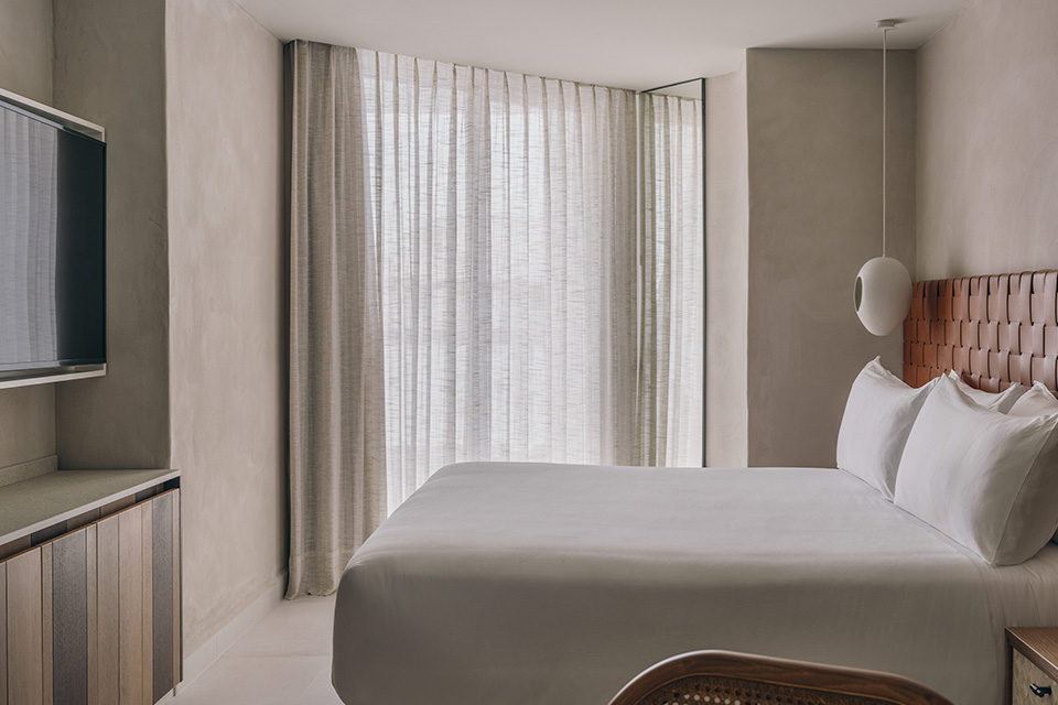 A cozy hotel room with a bed, chair, and television.