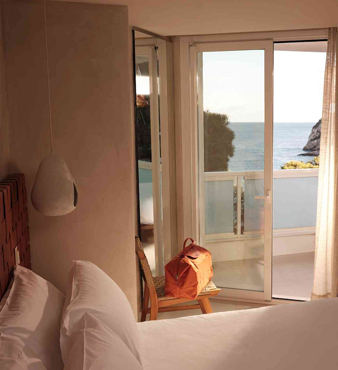 Bedroom with bed and balcony door with ocean views.