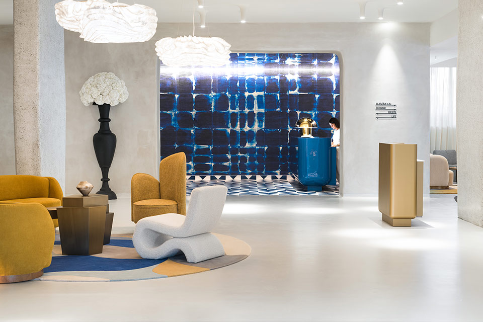 a bright lobby with modern furnishings and a check-in table at the back in a blue painted room