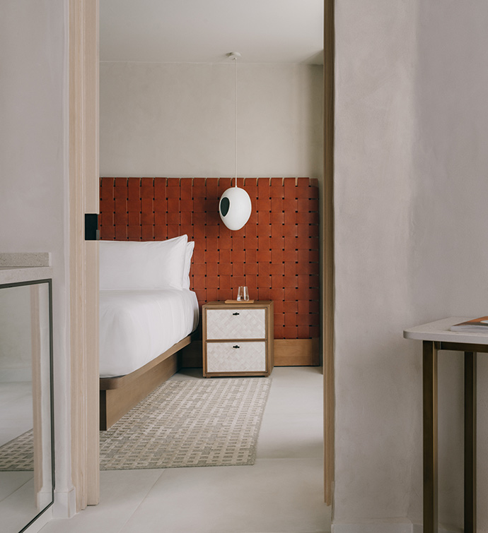 Bedroom with red headboard and white bed.