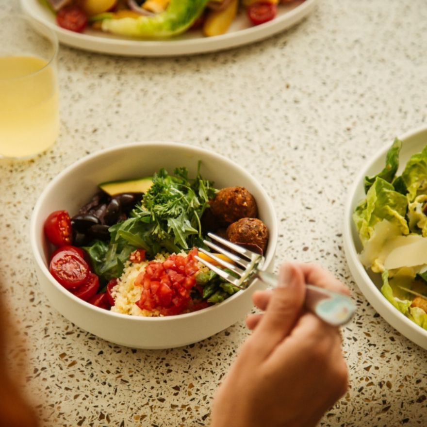 Fork held above a bowl full of vegetables