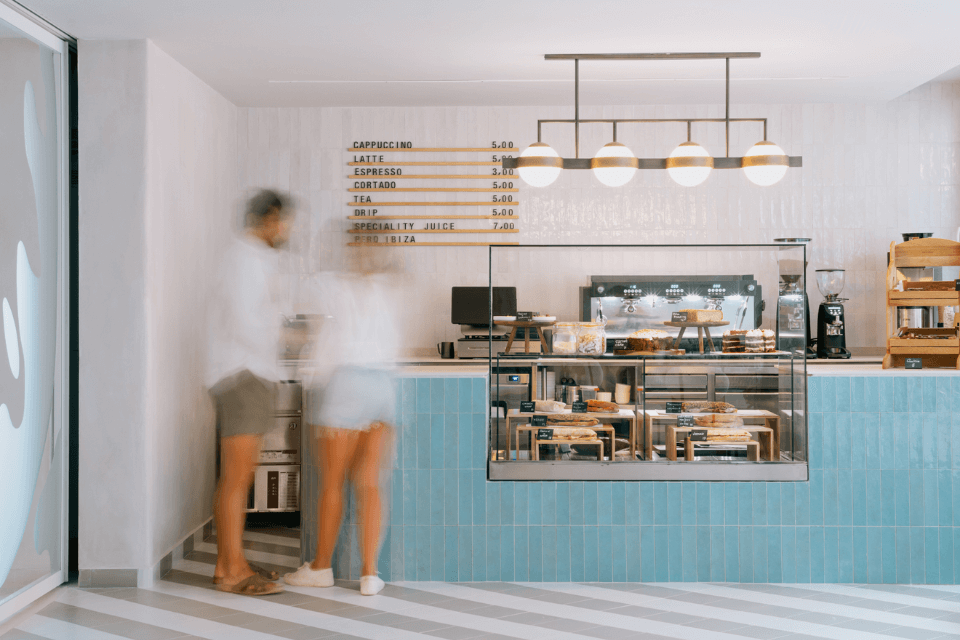 Coffee bar with turquoise blue counter and man and woman standing in front of it