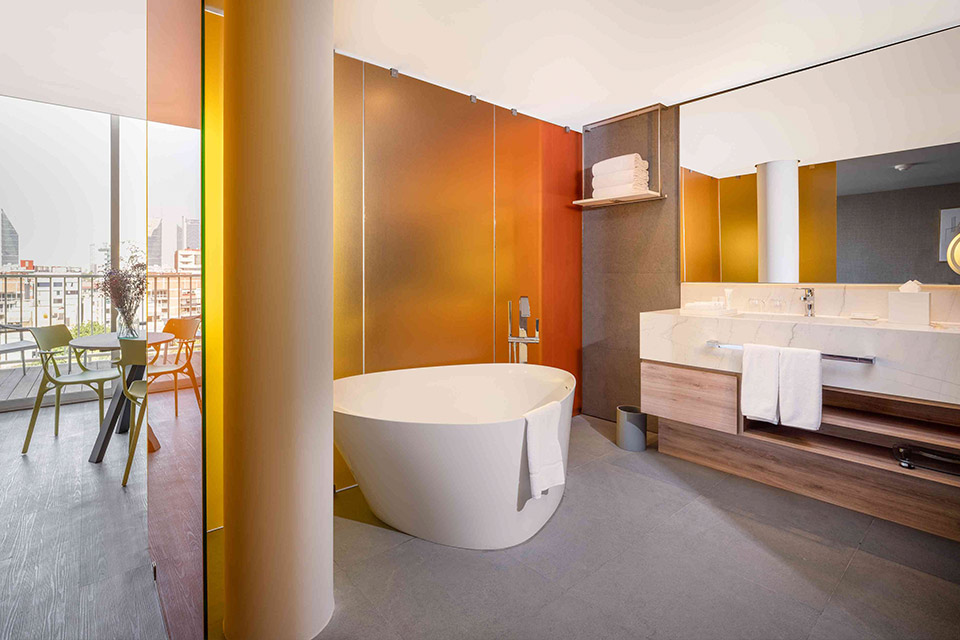 A spacious bathroom featuring a sizable tub and a generously sized mirror.