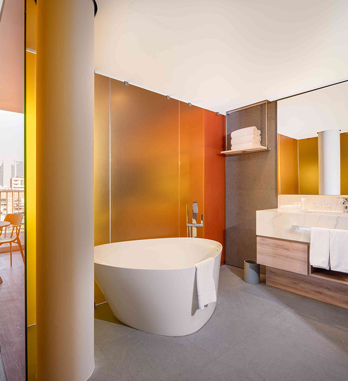 A spacious bathroom featuring a sizable tub and a generously sized mirror.