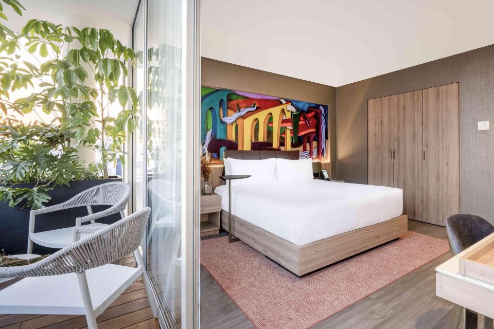 Hotel room with a colorful mural and outdoor patio