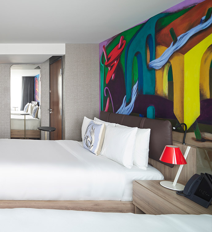 A hotel room with a large painting on the wall.