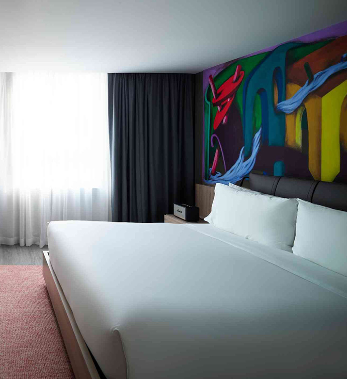 Colorful mural adorning hotel room wall.