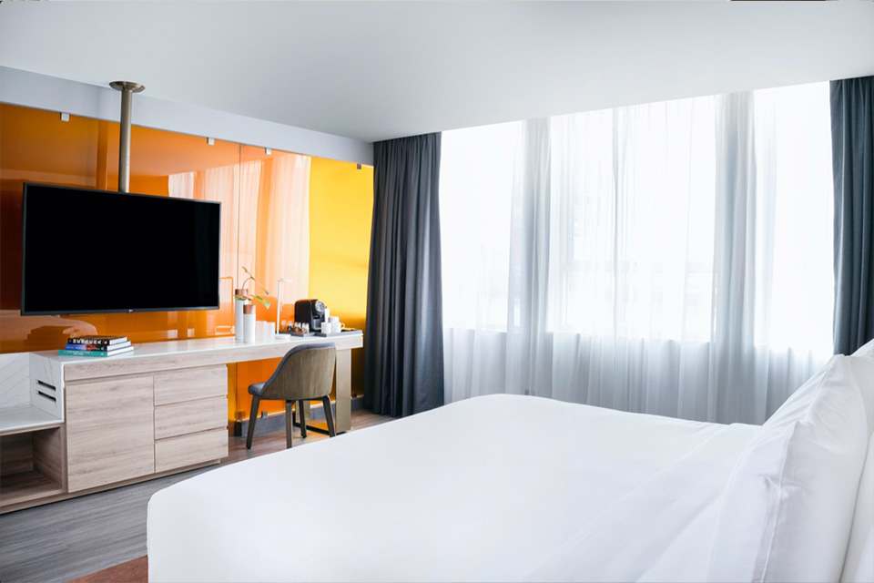 Hotel room with a bed, television and desk