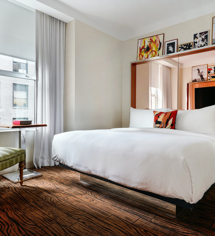 A cozy hotel room featuring a comfortable bed, a chair, and a window offering a scenic view.