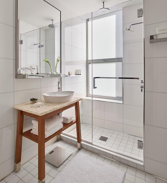 A modern bathroom with a sink, mirror, and shower.