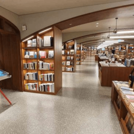 a bookstore with books placed in shelved underneath large archways