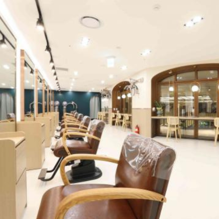 a bright salon with leather chairs facing the mirrrors