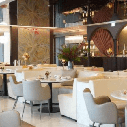 a dining room with white booths and grey chairs around the tables 