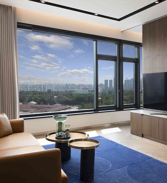 A contemporary hotel room with a spacious window offering a panoramic view of the cityscape.