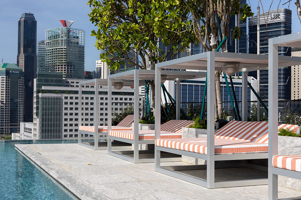 Rooftop pool with row of striped orange chaise lounges