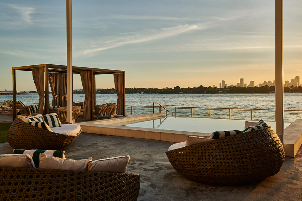 Infinity pool, cabanas and seating overlooking the water