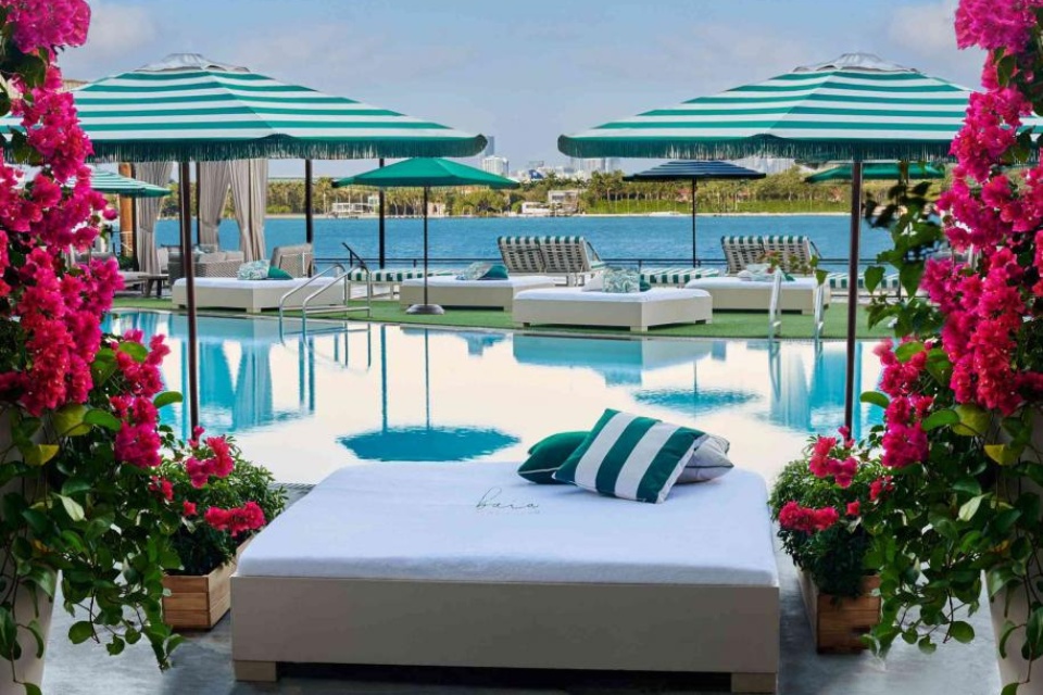 A pool and daybeds at Baia Beach Club at Mondrian South Beach