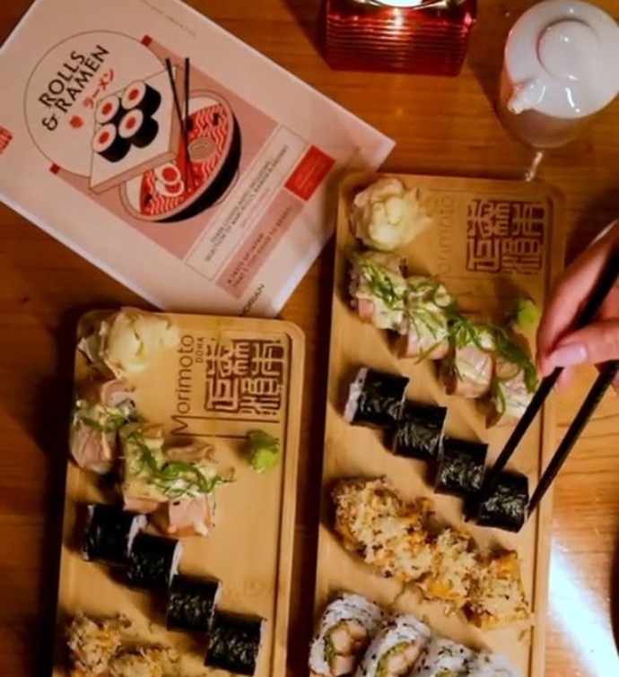 Platters of sushi and a Rolls & Ramen book at Morimoto Doha