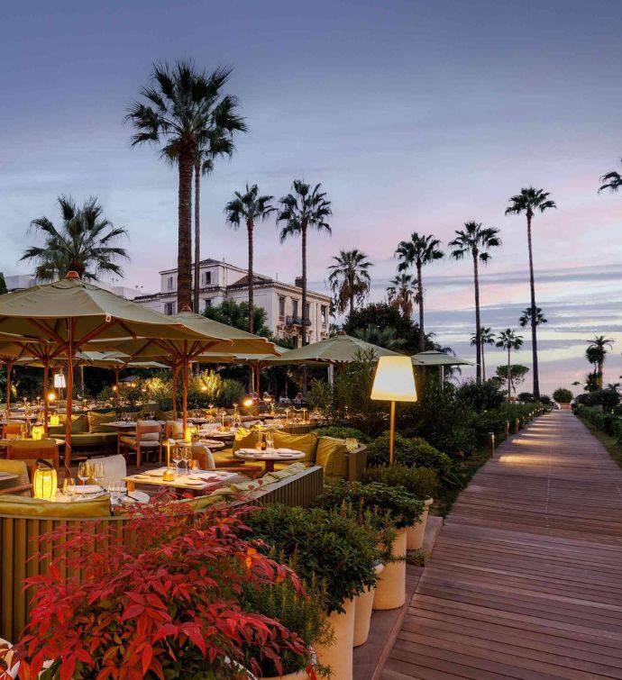 Beautiful outdoor dining patio with green umbrellas and a boardwalk