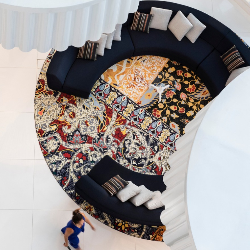 a lobby space from an aerial view with circular rugs and chairs and white tiles