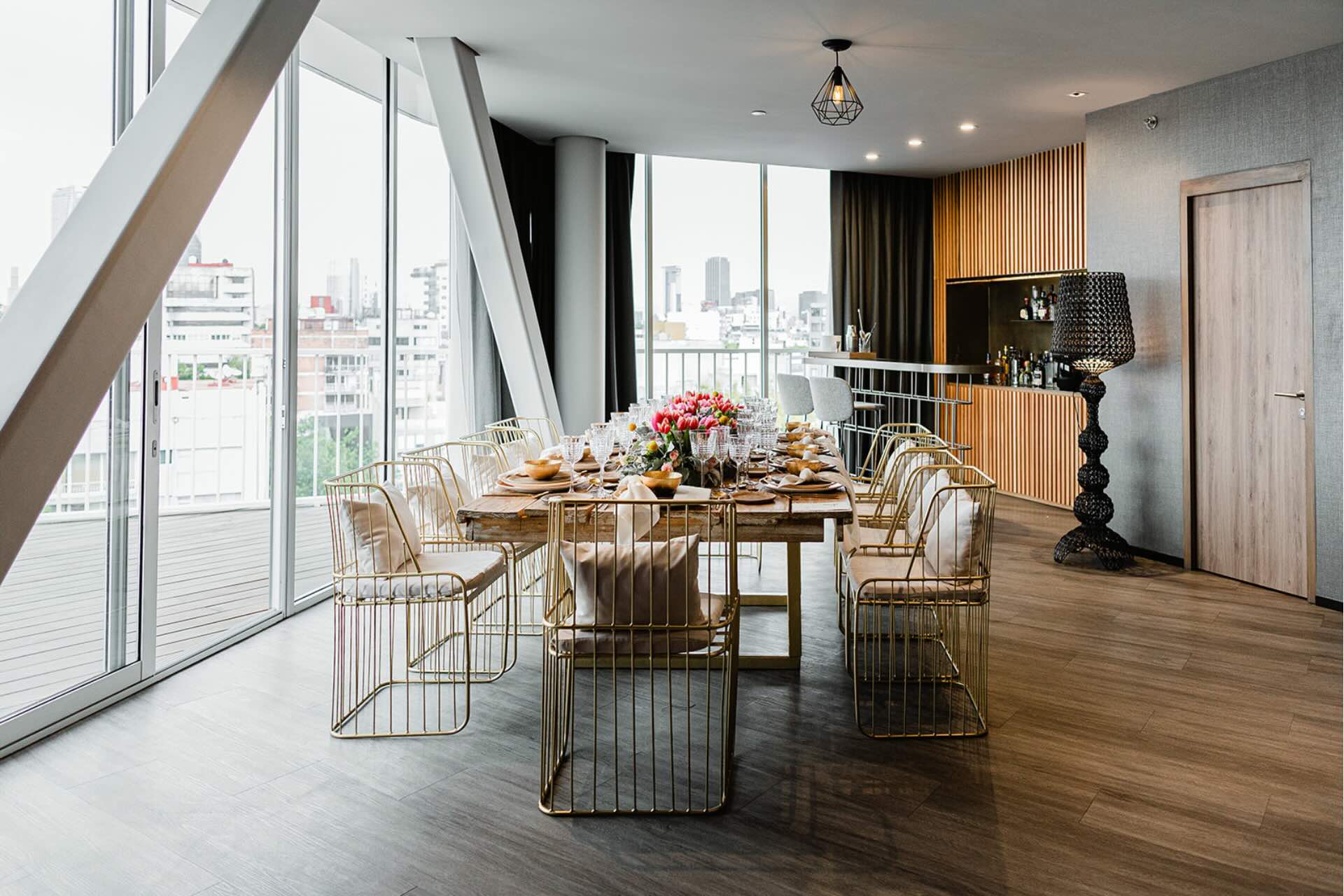 a small dining table set up in a penthouse with beautiful flowers and table settings