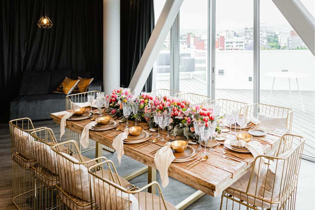 a dining table set up with florals and table settings